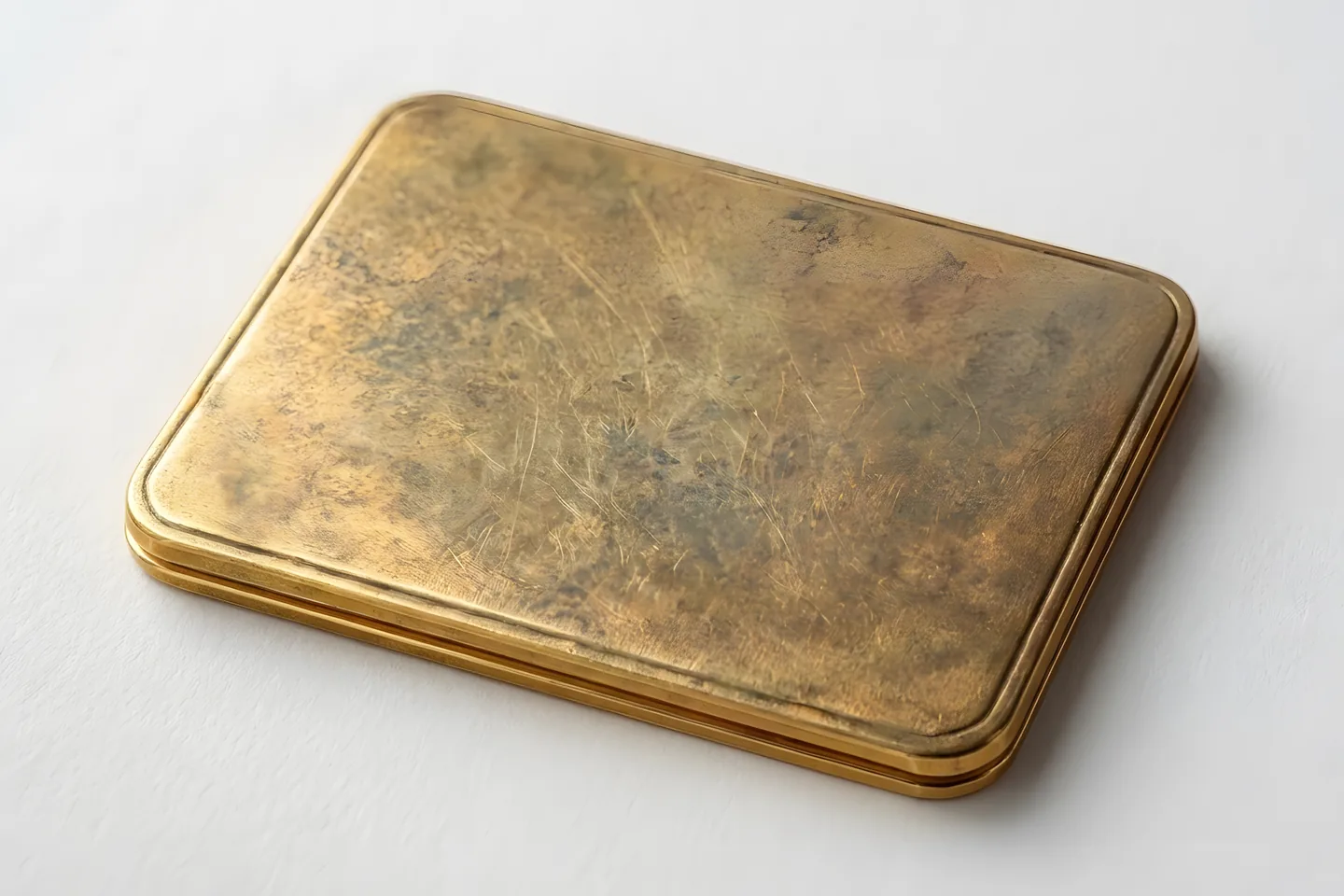 A gold-coloured metal surface with age and patina across it.